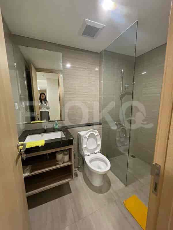 A contemporary bathroom with a sink, toilet, and shower stall.