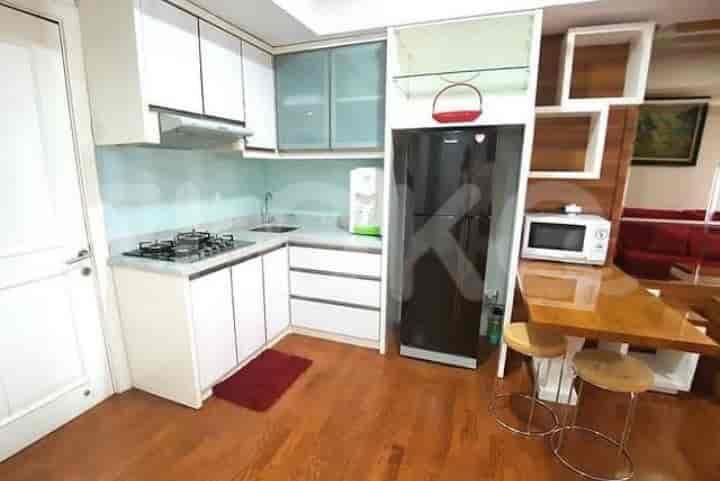 Well-equipped kitchen with white cabinets, a gas stove, and a black refrigerator.