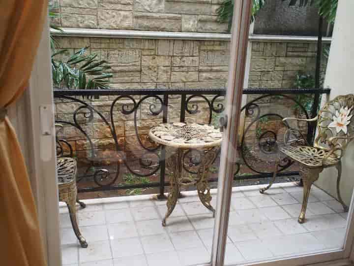 Balcony with outdoor furniture and a stone wall.