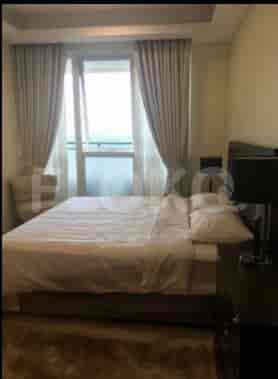 A bedroom with a double bed, nightstands, and large window.