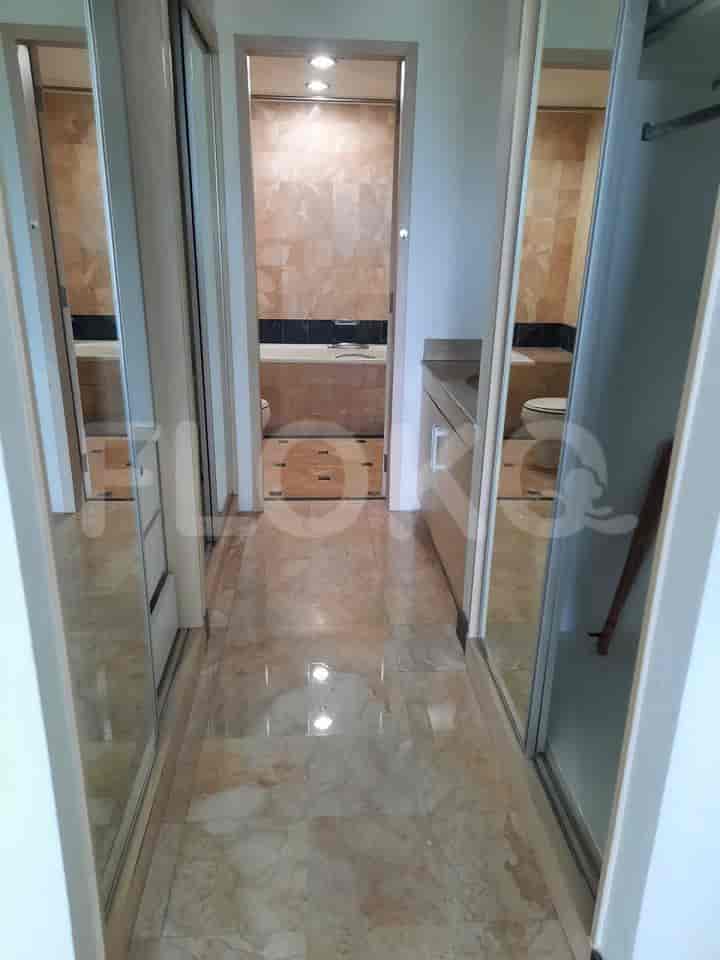 A hallway with a view into the bathroom and closets.
