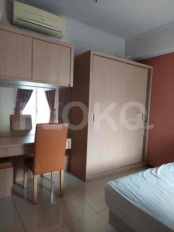 A bedroom featuring a desk, a large wardrobe, and a double bed.