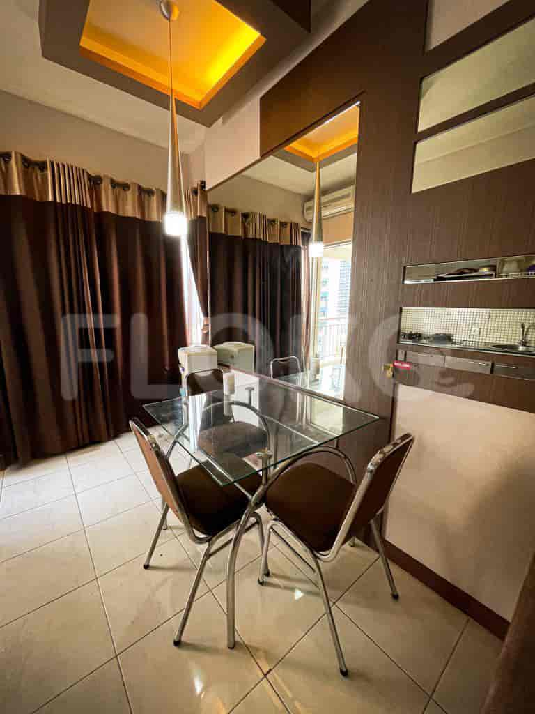 Dining area with glass table and chairs next to a kitchen.