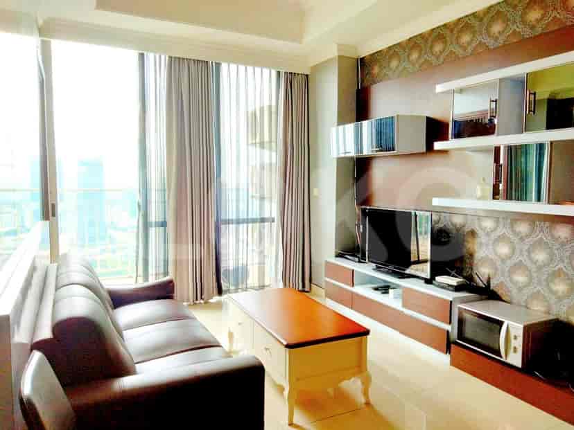 A modern living room with a large sofa, smart TV, and city view.