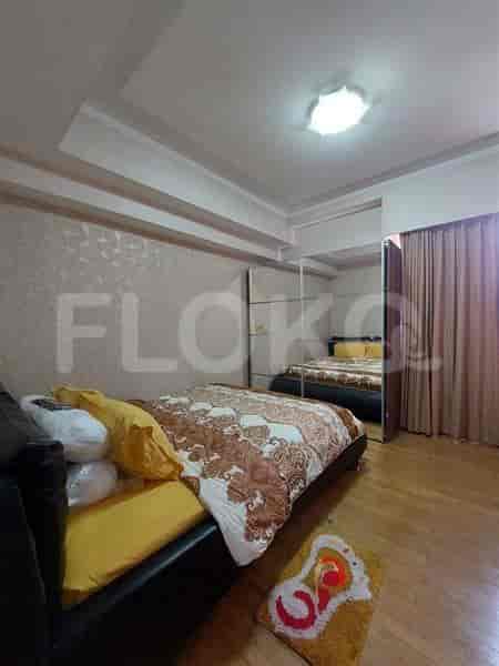 A bedroom with a double bed, wardrobe, and wooden flooring.