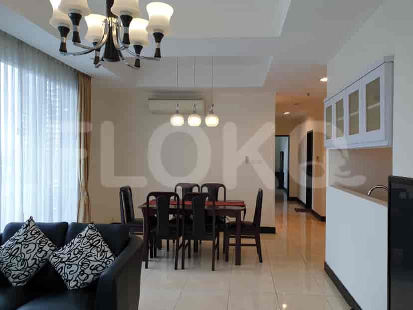 A dining room with table and chairs, connecting to the living room with sofa and air conditioning.