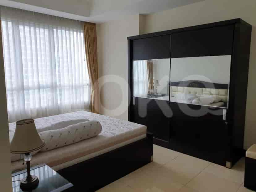 Bedroom featuring a king-size bed with a large mirror closet and sheer curtains.