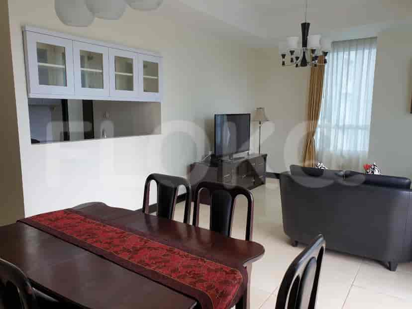 Combined dining and living area with a dining table, chairs, and a dark grey sofa.