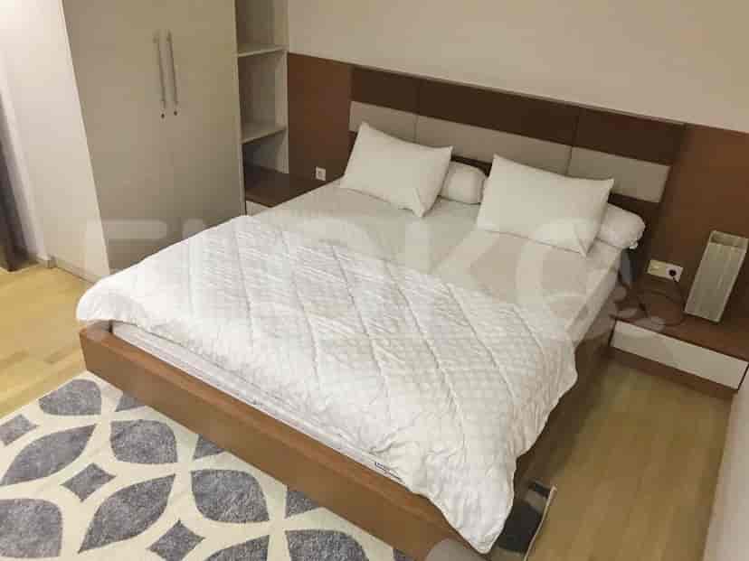 A cozy bedroom featuring a double bed with a wooden bed frame, bedside tables, and a wardrobe.