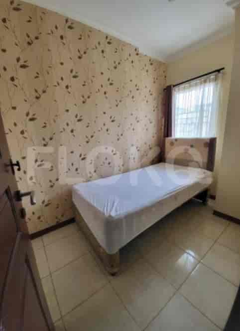 A small bedroom with a single bed, patterned wallpaper, and tiled flooring.