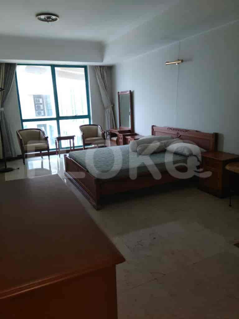 A spacious bedroom with a large bed and a vanity.