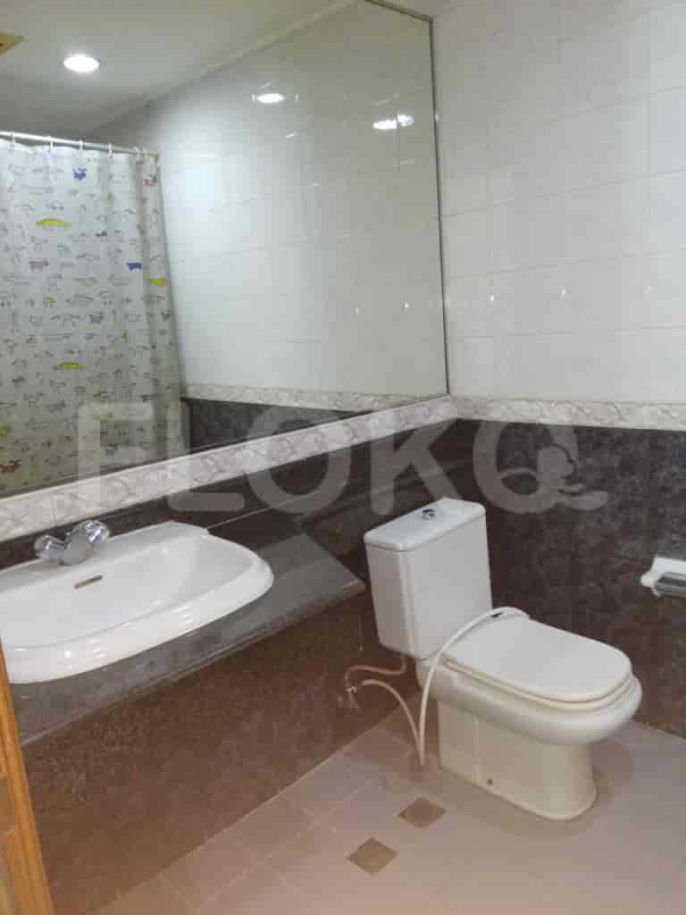 A bathroom with a toilet, sink, and a large mirror.