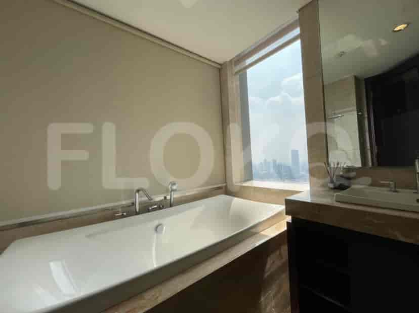 Kamar mandi modern dengan bathtub, wastafel, dan pemandangan kota.