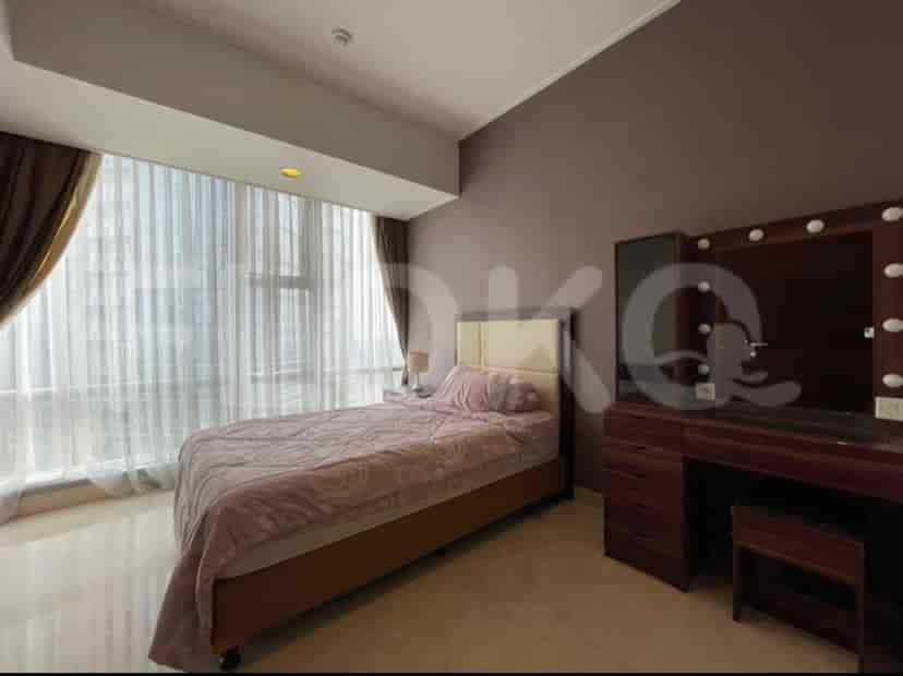 Kamar tidur modern dengan tempat tidur berukuran queen, meja rias, dan jendela besar.