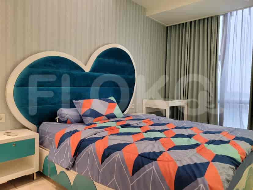 A children's bedroom with a heart-shaped headboard, a bed with colorful bedding and a nightstand.