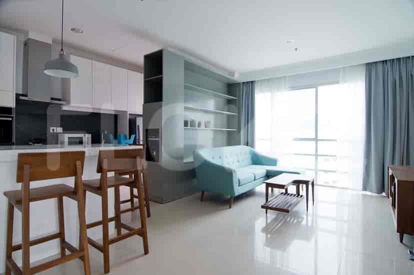 Modern living space with a combined kitchen and living area, featuring a breakfast bar, sofa, and built-in shelving.