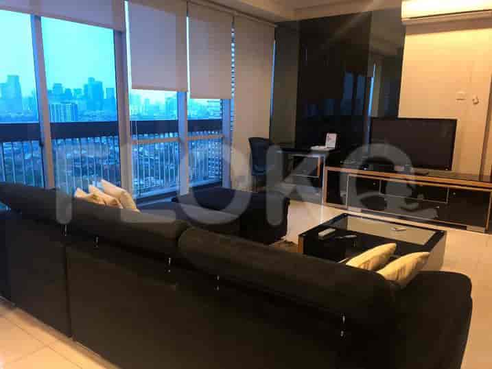 Living room interior with a sofa, TV console, and a stunning city view.