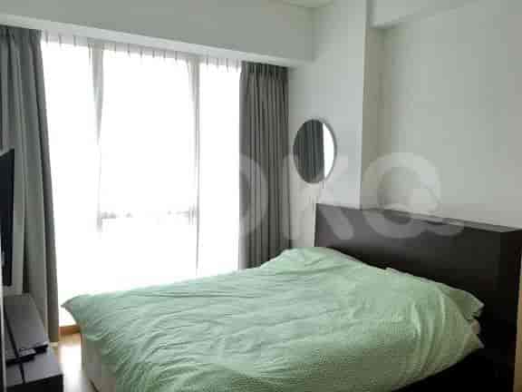A bedroom with a queen-sized bed and large windows.