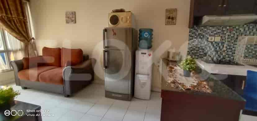 Living room and kitchen with a sofa, a refrigerator and a water dispenser.