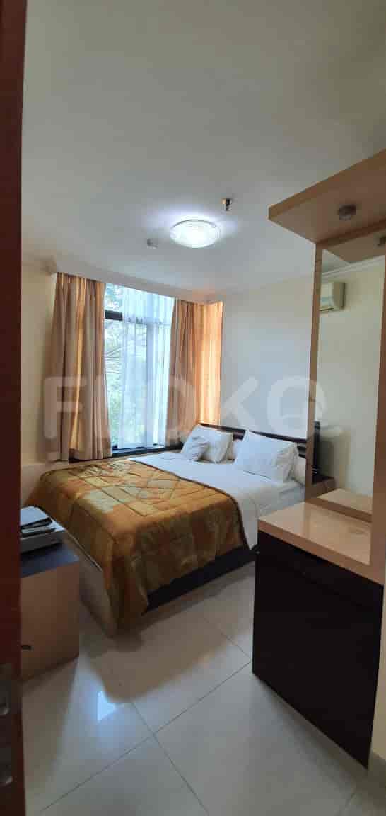 A well-lit master bedroom featuring a double bed, a large window, and a mirror.