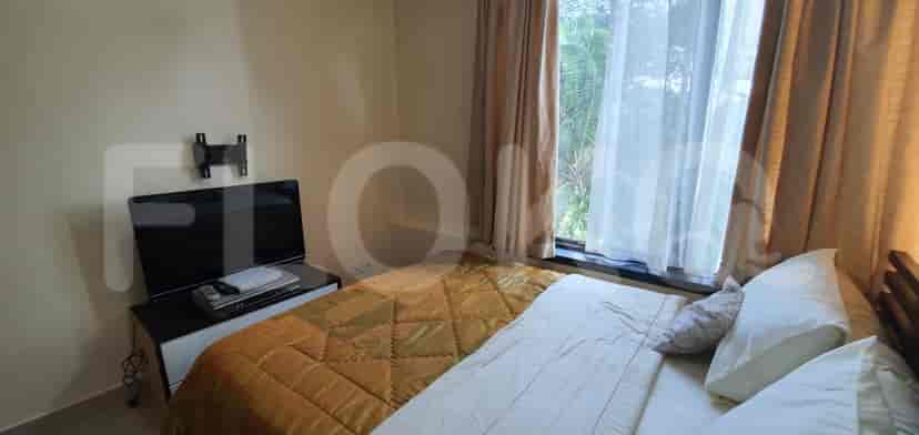 A bedroom with a double bed, TV and large window