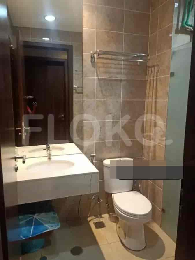A compact bathroom featuring a modern vanity, toilet, and towel rack.