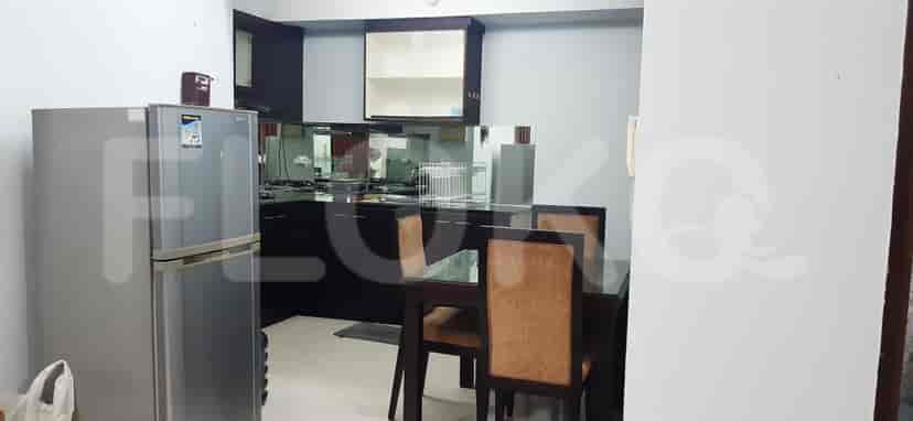 The kitchen with a refrigerator and a dining area visible.