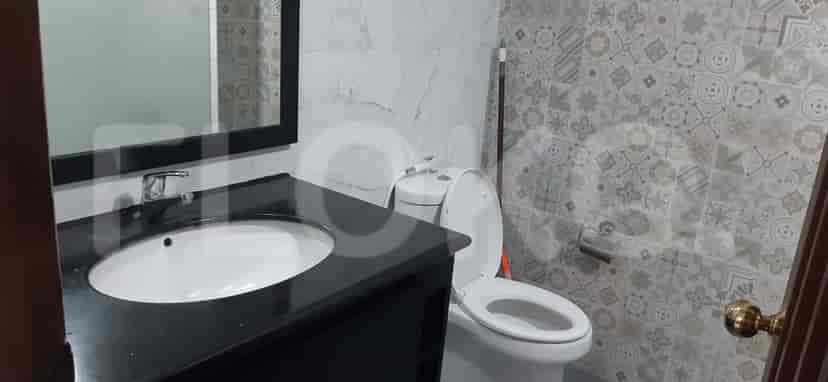 Bathroom with a toilet, sink, and mirror.