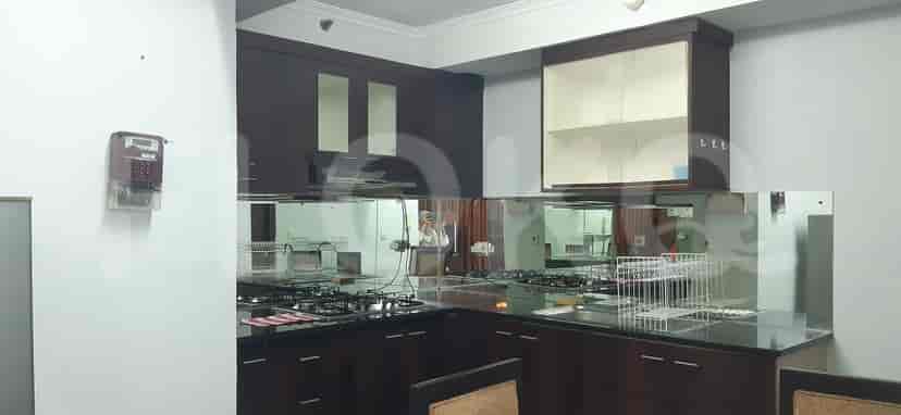 Modern kitchen with dark wooden cabinets, a gas stove, and a mirrored backsplash.