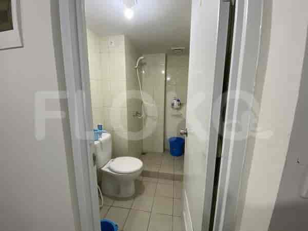 Kamar mandi kecil dengan toilet, shower, dan wastafel.