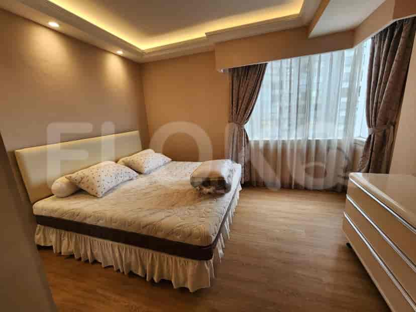 Bedroom with a bed, large window, and warm color scheme.