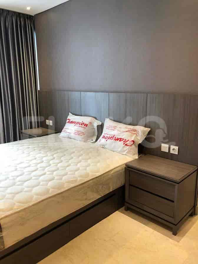 A bedroom featuring a bed with Champion pillows, bedside tables, and a dark wall.