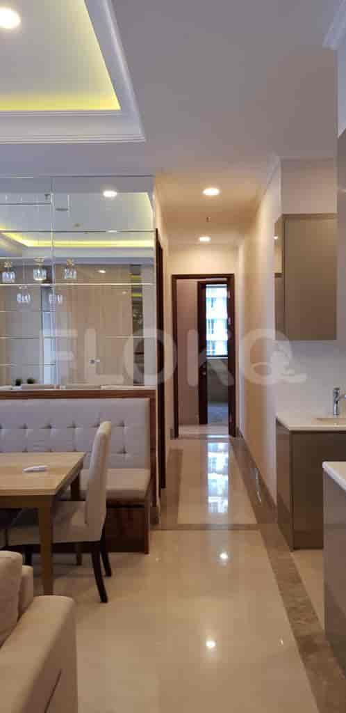 Long hallway with marble flooring, leading towards a door.