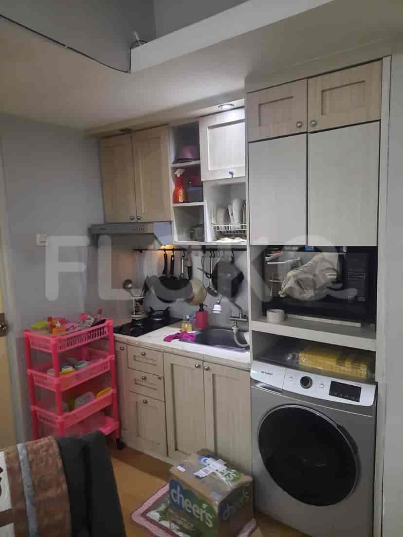 A compact kitchen with appliances, cabinets, and cooking utensils.