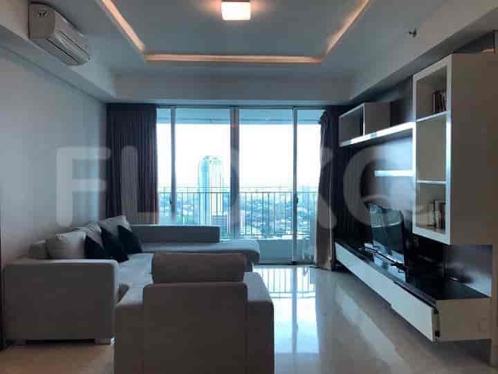 Modern living room with a grey L-shaped sofa, large windows, and a city view.