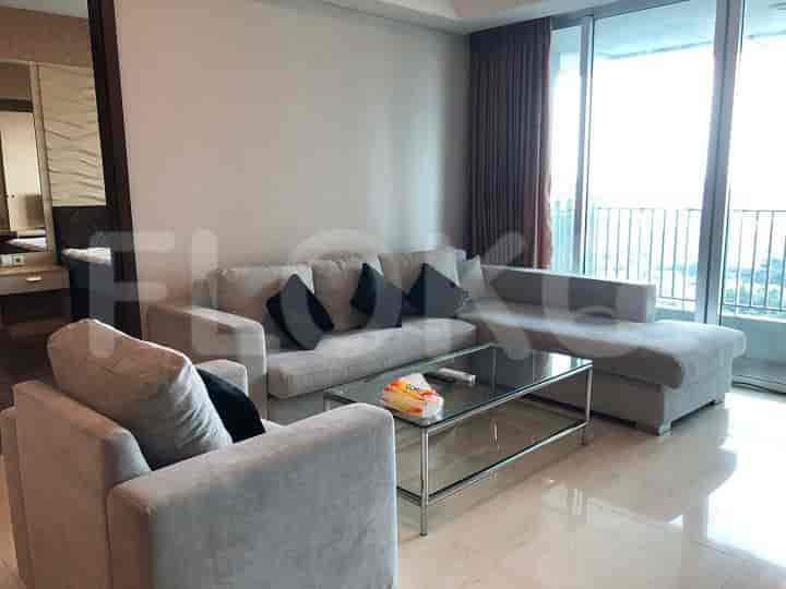 Living room with a grey sofa, glass coffee table, and city view.