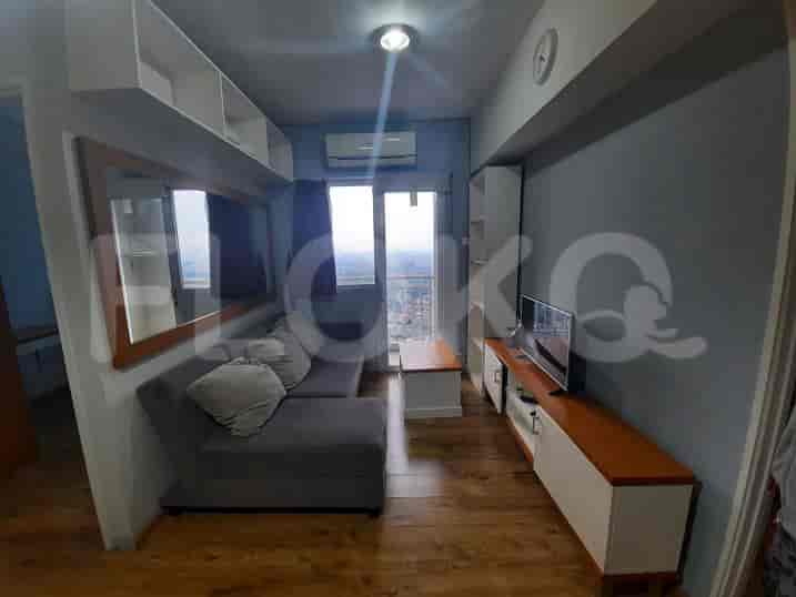 A modern living room featuring a grey sofa, a wall-mounted TV, and a view of the city.