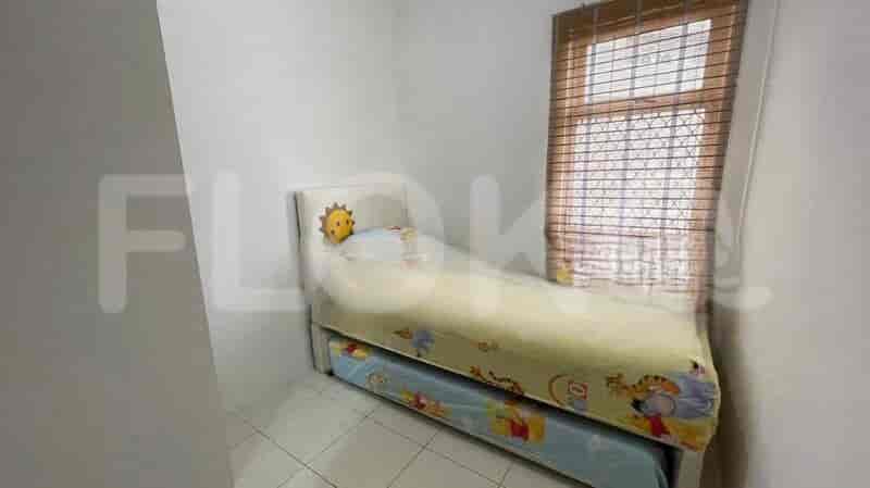 A small bedroom with a twin bed that has a pull-out trundle bed underneath, decorated with cartoon characters.