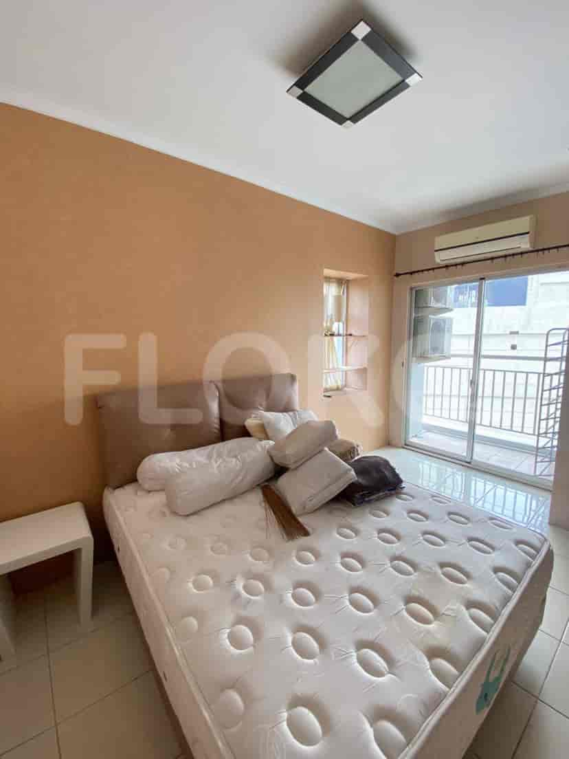 Kamar tidur dengan tempat tidur ganda, meja samping, dan akses ke balkon.