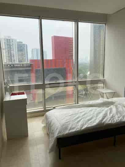 Bedroom with a bed and large windows overlooking the city.