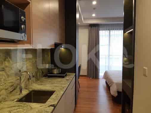 View of a kitchenette area and a glimpse of the bedroom with curtains.