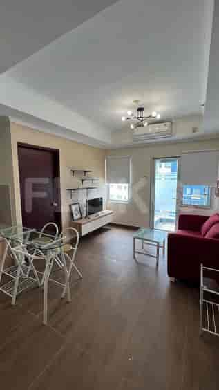 A combined living and dining area with a small table, sofa, and TV.