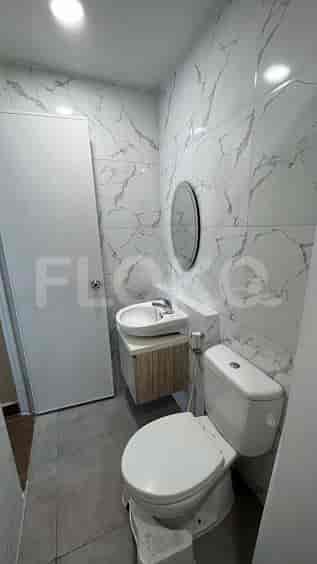A bathroom with a toilet, sink, and mirror.