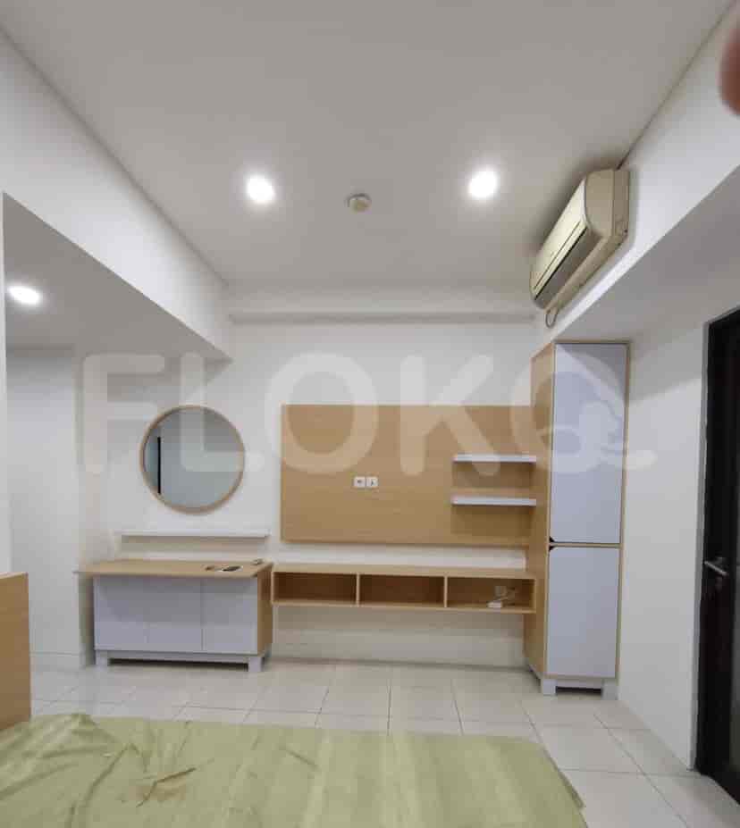 Bedroom with a wooden bed frame, built-in cabinets, and a wall-mounted entertainment unit.
