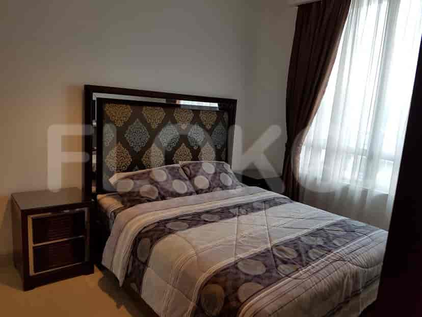A modern bedroom with a patterned headboard, bedside table, and large window.