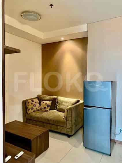 Compact living room with a sofa and kitchen area.
