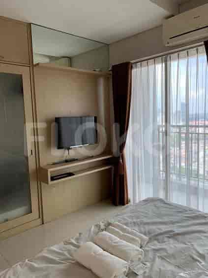 Bedroom with a bed, curtains, and a view of the city.
