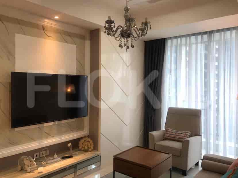 Living room with a TV, decorative walls, and a comfortable seating area.