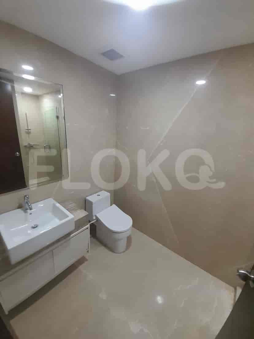 Bathroom with a toilet, sink, and mirror.