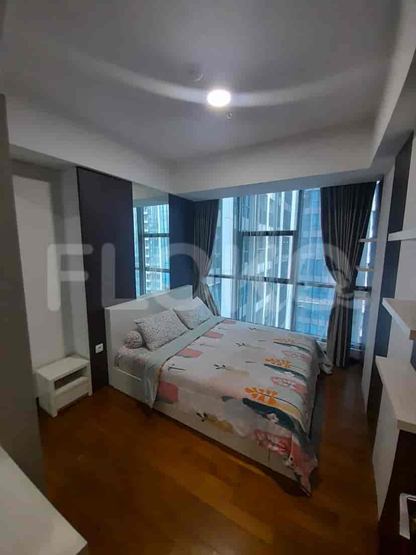 Bedroom with queen bed, large windows, and city views.